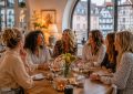 Groupe de femmes partageant un moment convivial autour d’une table lors d’une réunion chaleureuse et élégante à Strasbourg.