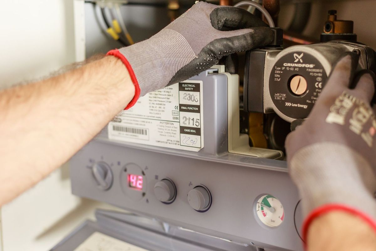 Technicien inspectant un appareil électrique avec gants et outils