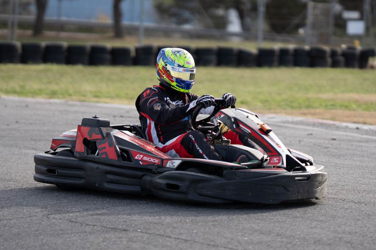 Pilote de karting en action sur un circuit, casque vissé sur la tête Pilote de karting en action sur un circuit, casque vissé sur la tête