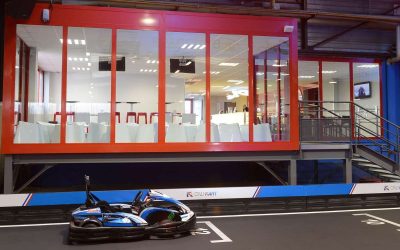 Un kart sur piste intérieure devant une salle vitrée