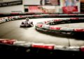 Un kart rouge avec pilote navigant un virage de circuit intérieur