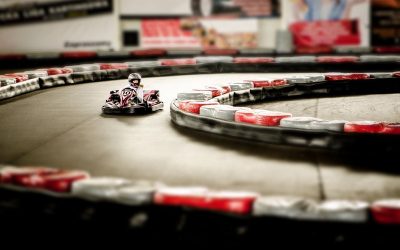 Un kart rouge avec pilote navigant un virage de circuit intérieur